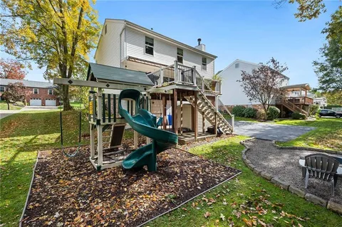 a view of a big house with wooden fence