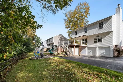 a view of a white house with large windows and a table and chairs