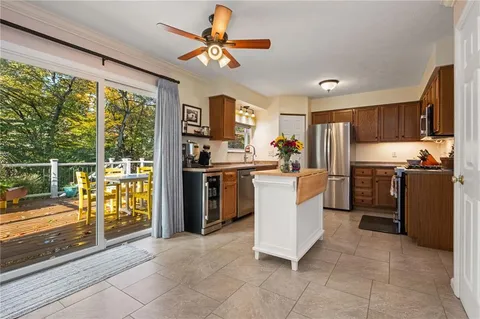 a kitchen with a refrigerator a stove top oven a sink dishwasher and wooden cabinets