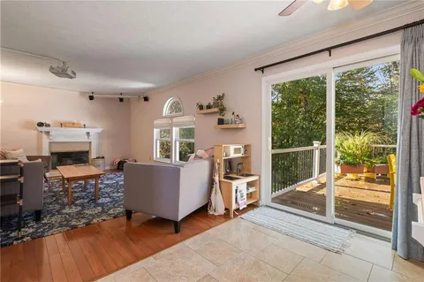 a living room with furniture a fireplace and a floor to ceiling window