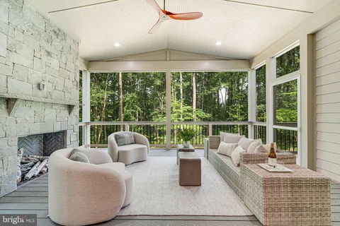 a view of a hallway to a livingroom with wooden floor and stairs