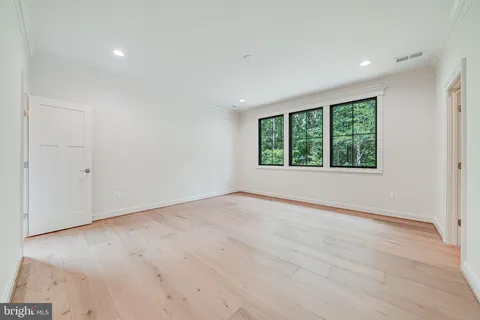 an empty room with wooden floor and a window