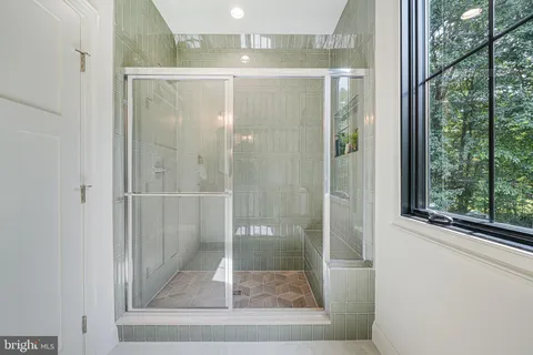 a kitchen with white cabinets and a window