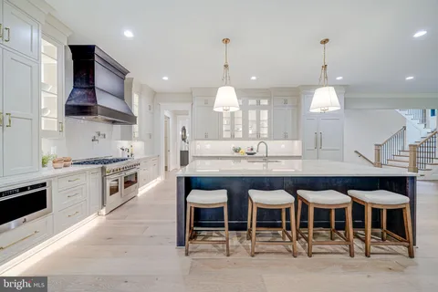 a kitchen with granite countertop a stove a sink a center island and a window