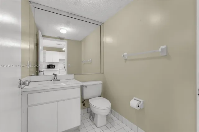 a bathroom with a toilet a sink a mirror and vanity