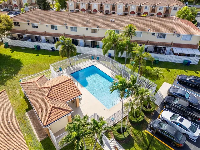 an aerial view of a house with garden space and swimming pool