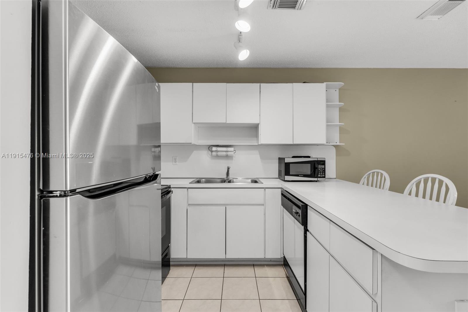 6263 Southwest 139th Avenue Miami, FL 33183 - Photo 8 of 38 a kitchen with stainless steel appliances a refrigerator sink and cabinets