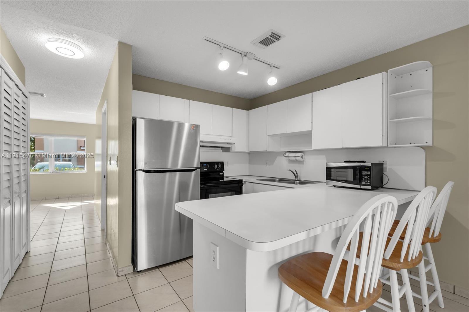6263 Southwest 139th Avenue Miami, FL 33183 - Photo 9 of 38 a kitchen with a sink a refrigerator and a stove top oven