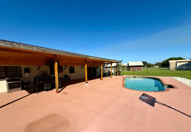 a swimming pool with outdoor seating and yard