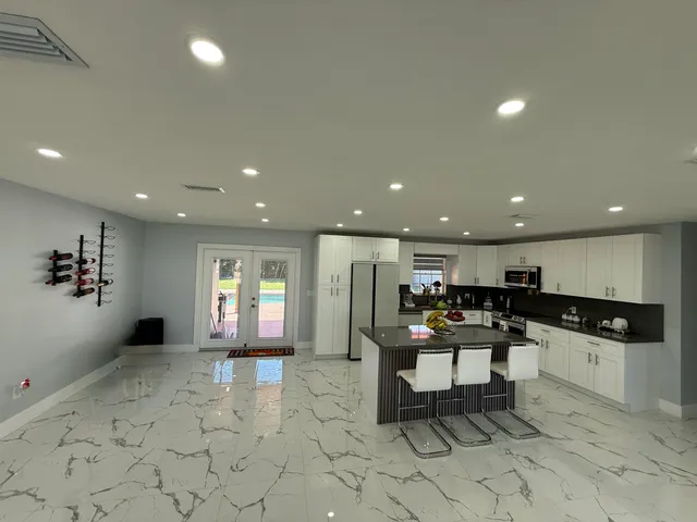 a kitchen with stainless steel appliances kitchen island granite countertop a sink and cabinets