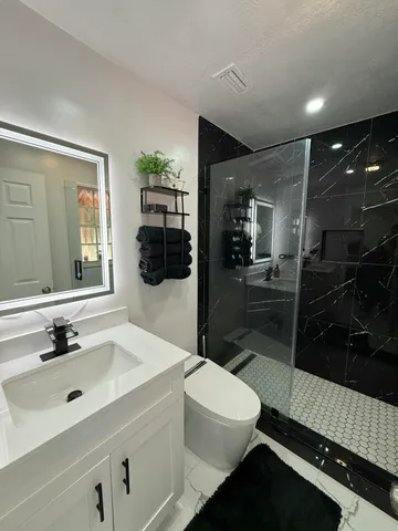 a bathroom with a sink a toilet and shower