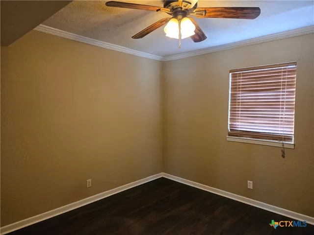 a view of a small space with wooden floor and a window