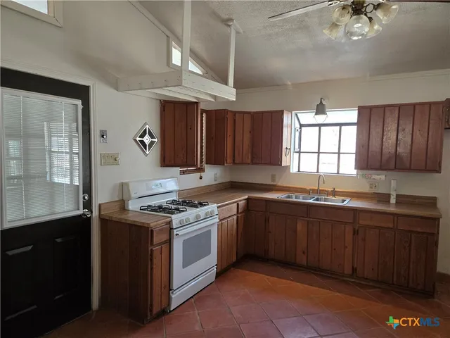 a kitchen with a stove sink and cabinets