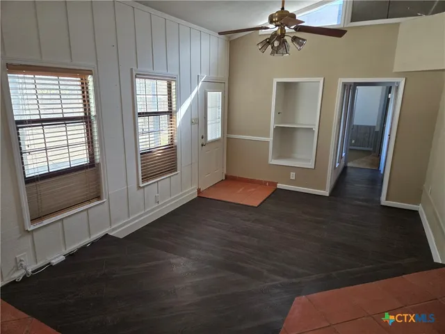 a view of an empty room with a fireplace and a window
