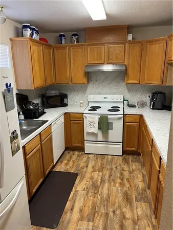 a kitchen with a stove top oven sink and cabinets