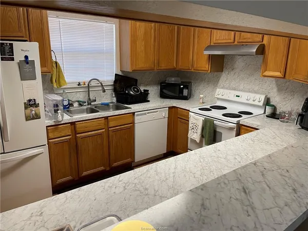 a kitchen with a sink a stove and cabinets
