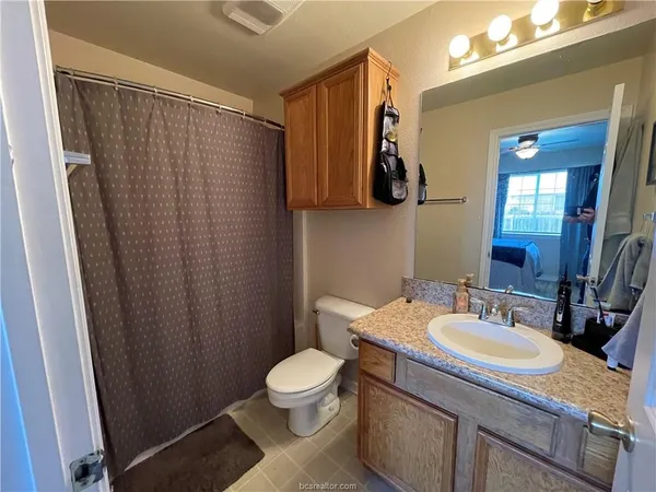 a bathroom with a granite countertop sink toilet and shower