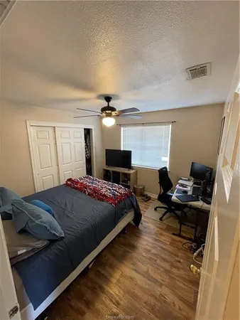 a bedroom with a bed wooden floor and window