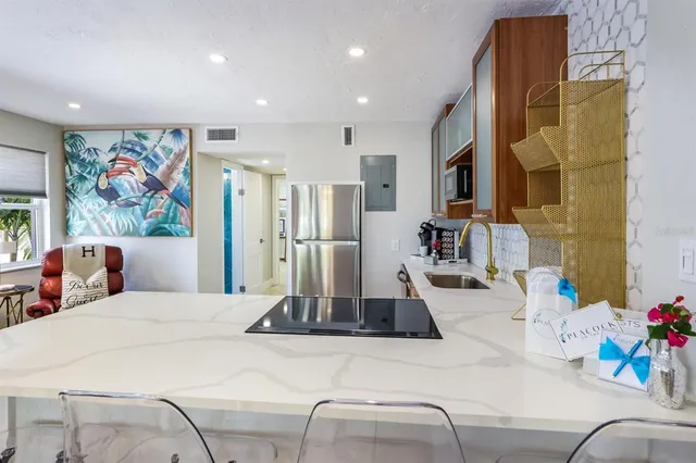 a living room with furniture a flat screen tv and kitchen view