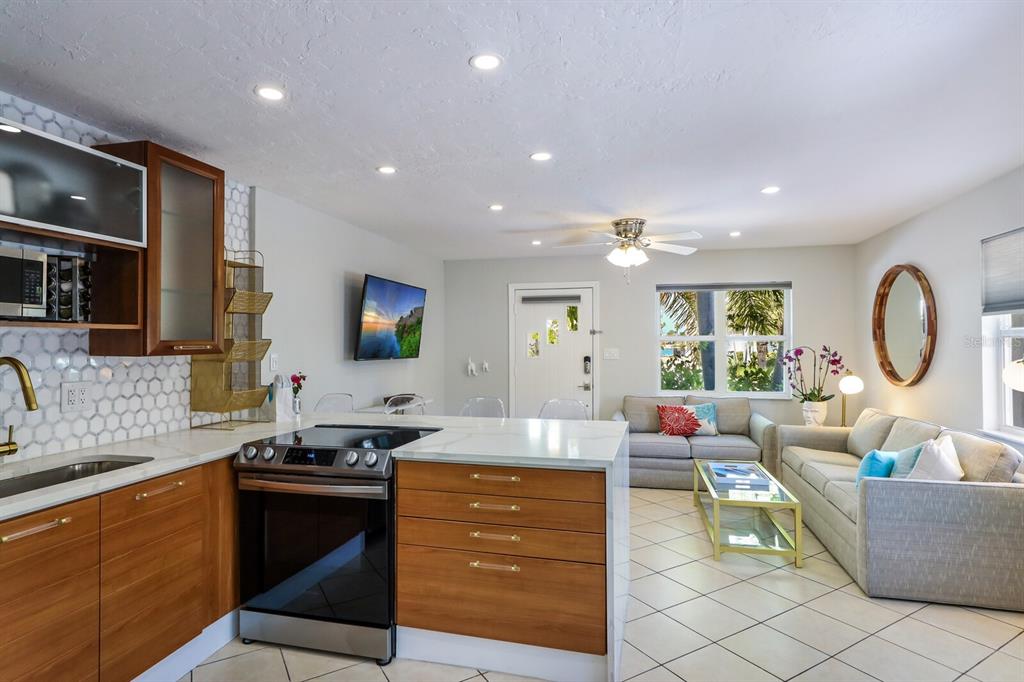161 Golden Gate Point, Unit 1 Sarasota, FL 34236 - Photo 21 of 79 a living room with furniture a flat screen tv and kitchen view