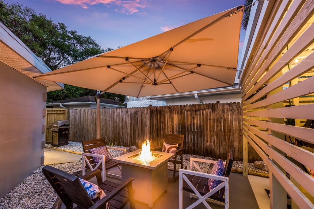 161 Golden Gate Point, Unit 1 Sarasota, FL 34236 - Photo 35 of 79 a view of a backyard with table and chairs under an umbrella with a small yard