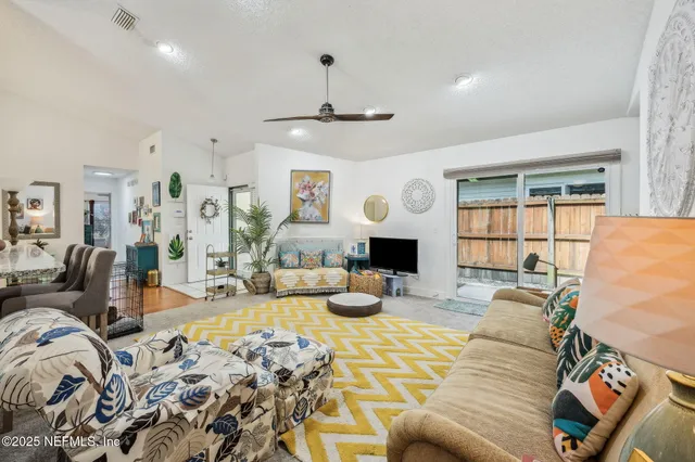 a living room with furniture a chandelier and a flat screen tv