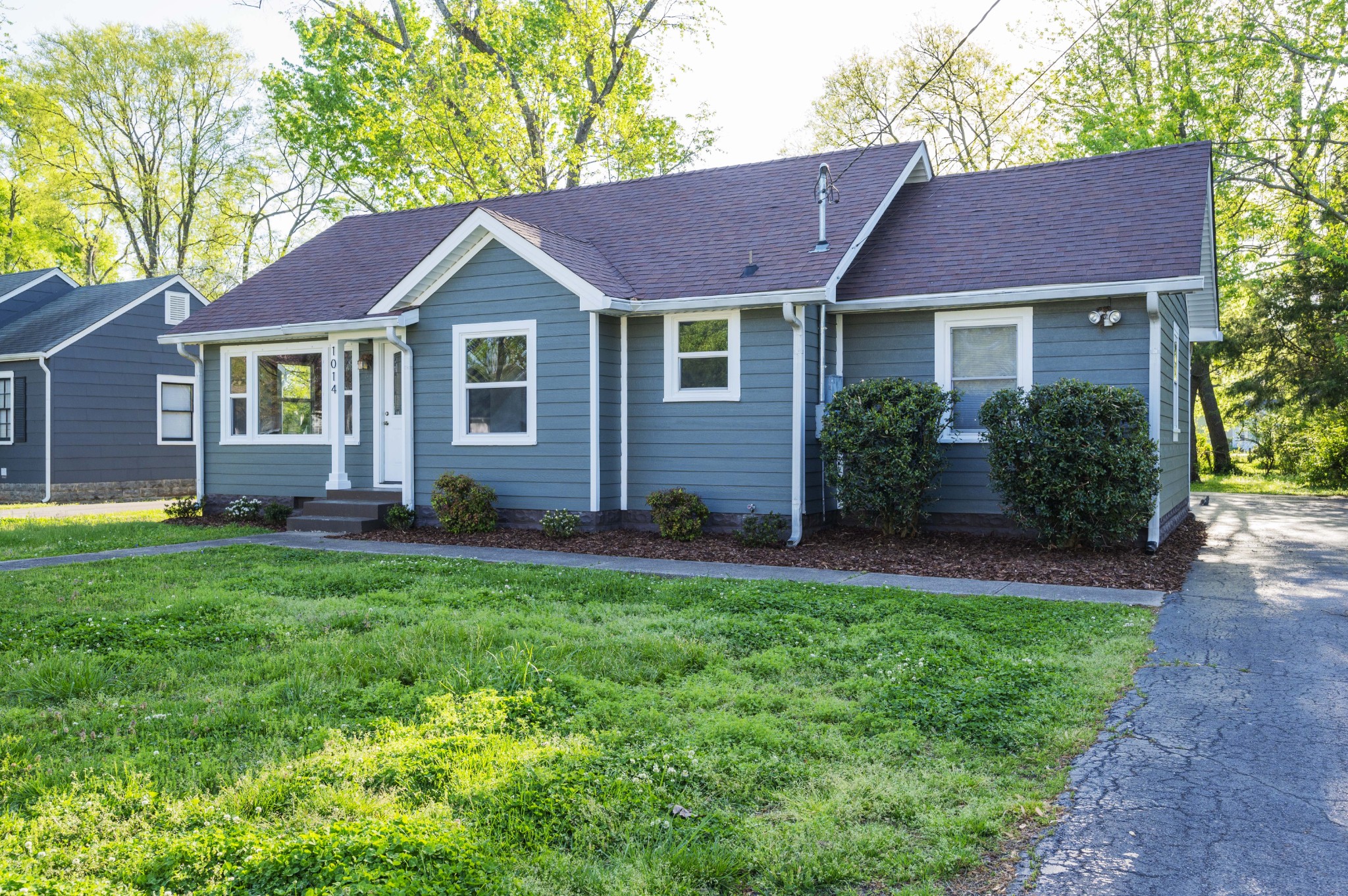 a front view of a house with a yard and garden