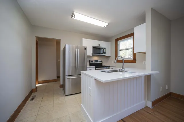 a kitchen with stainless steel appliances a sink stove refrigerator and cabinets