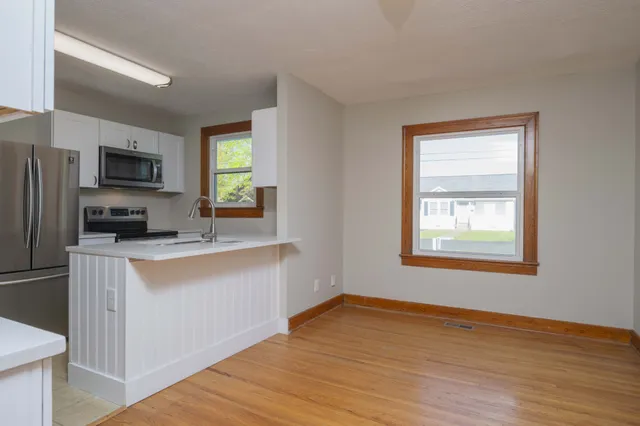 a kitchen with cabinets and wooden floor