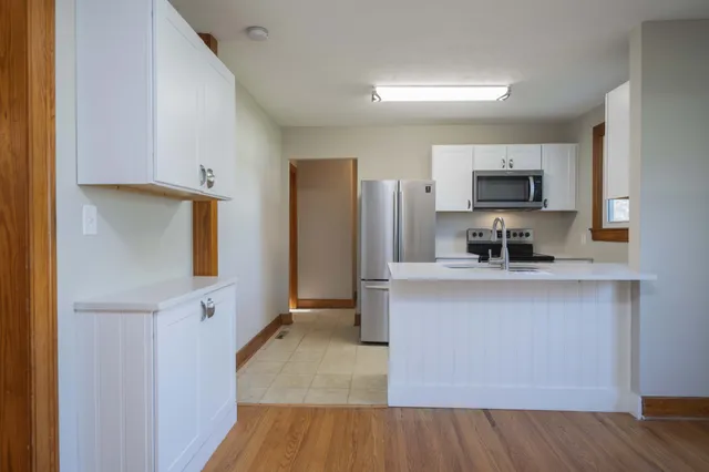 a kitchen with stainless steel appliances a refrigerator sink and microwave