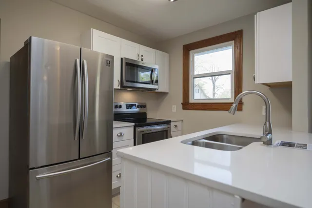 a kitchen with stainless steel appliances granite countertop a refrigerator sink and stove