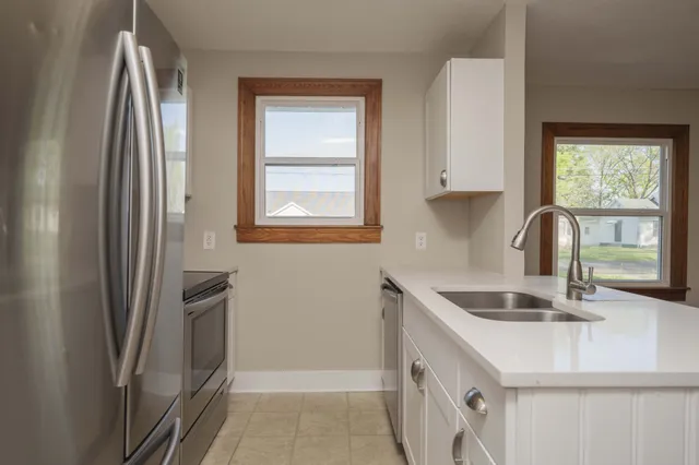 a kitchen with stainless steel appliances granite countertop a sink and a refrigerator