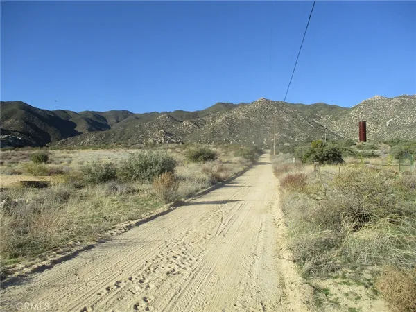 a view of a dry yard with mountains in the background