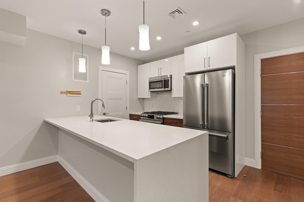 425 Lagrange Street, Unit 203 Boston, MA 02132 - Photo 16 of 31 a kitchen with a refrigerator a sink and a oven