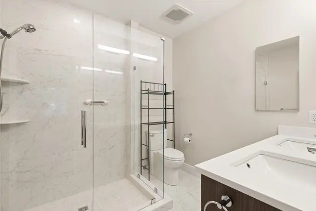 a bathroom with a sink a toilet and shower