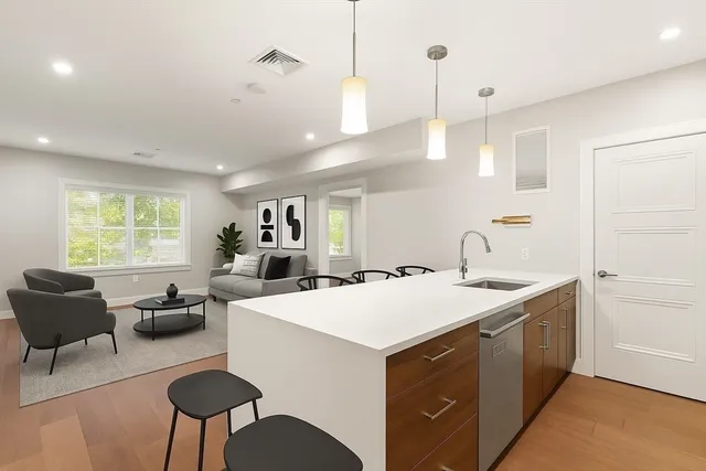 a kitchen with a dining table chairs sink and white cabinets