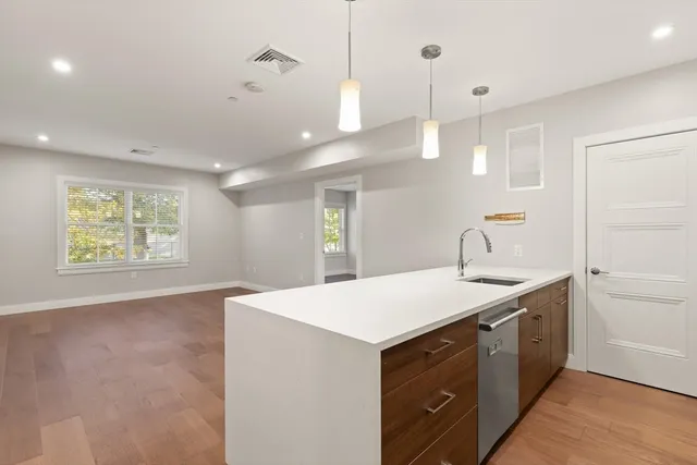 a kitchen with a sink cabinets and wooden floor