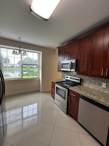 a kitchen with stainless steel appliances granite countertop a stove a sink and a microwave