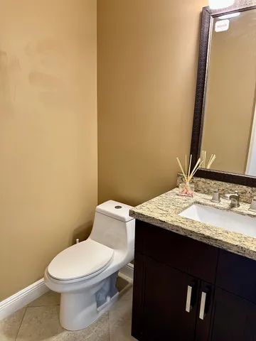 a bathroom with a granite countertop toilet and sink