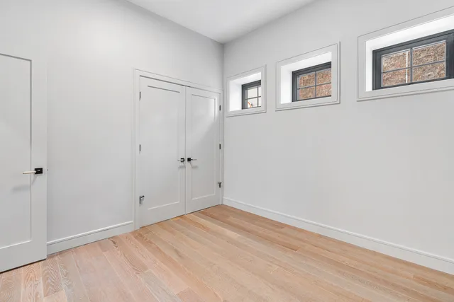 a view of empty room with wooden floor and window