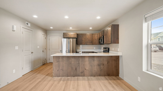 1223 East 1775 North Payson, UT 84651 - Photo 24 of 45 Open-concept kitchen with wood-finish flooring, stainless steel appliances, a breakfast bar island, recessed lighting, and white countertops