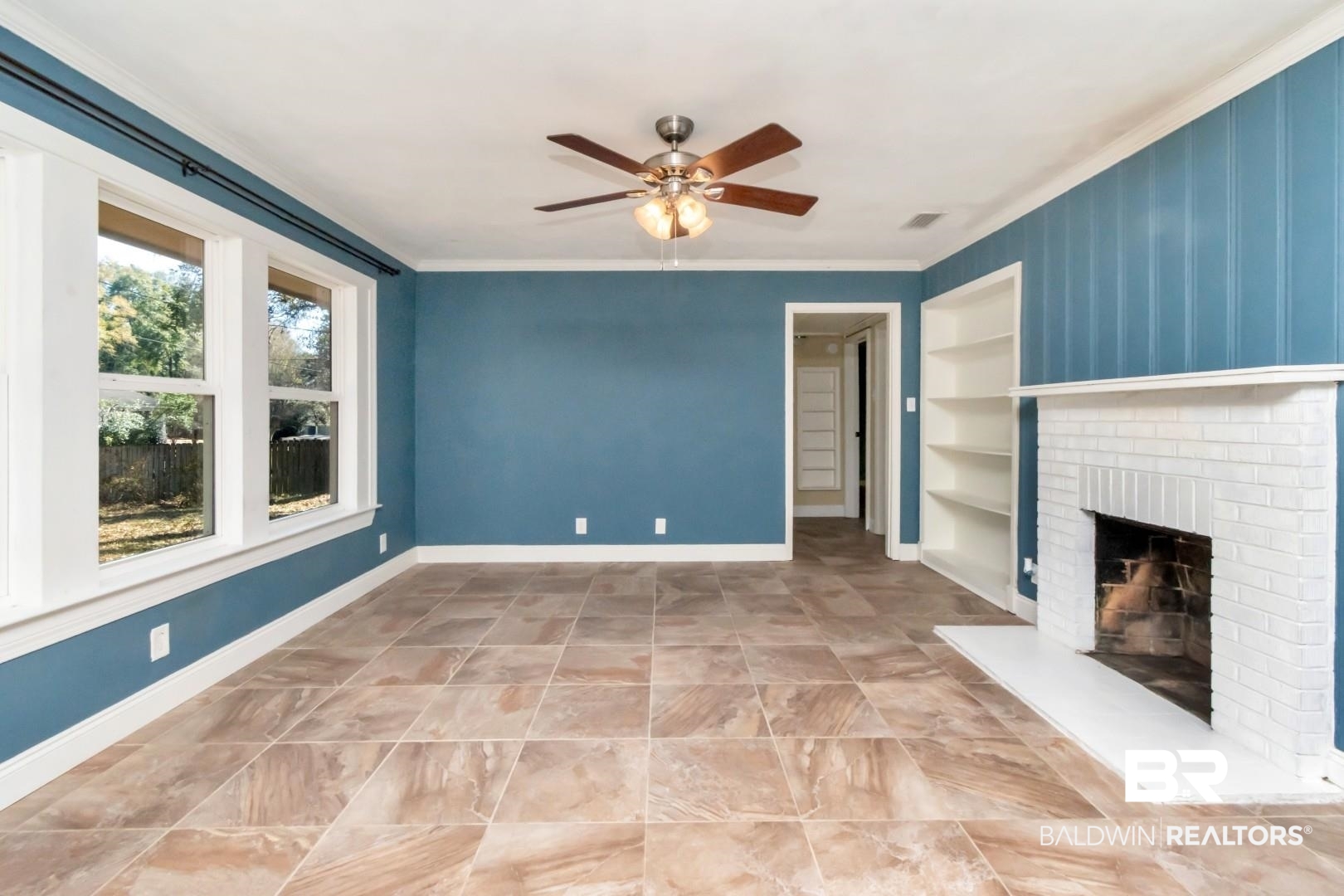 410 St John Place Mobile, AL 36609 - Photo 3 of 32 Unfurnished living room with built in shelves, ceiling fan, crown molding, and a fireplace