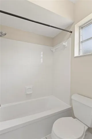 a bathroom with a toilet and a bath tub