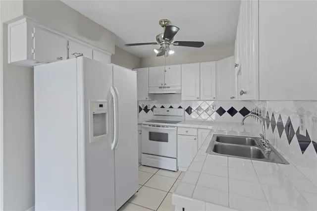 a kitchen with granite countertop a refrigerator and a sink