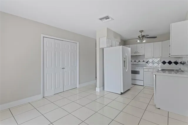 a kitchen with a refrigerator a sink and cabinets