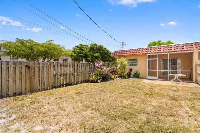 a view of a house with a yard and potted plants