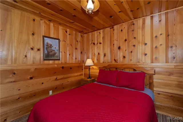 a bedroom with a bed a dresser next to a window