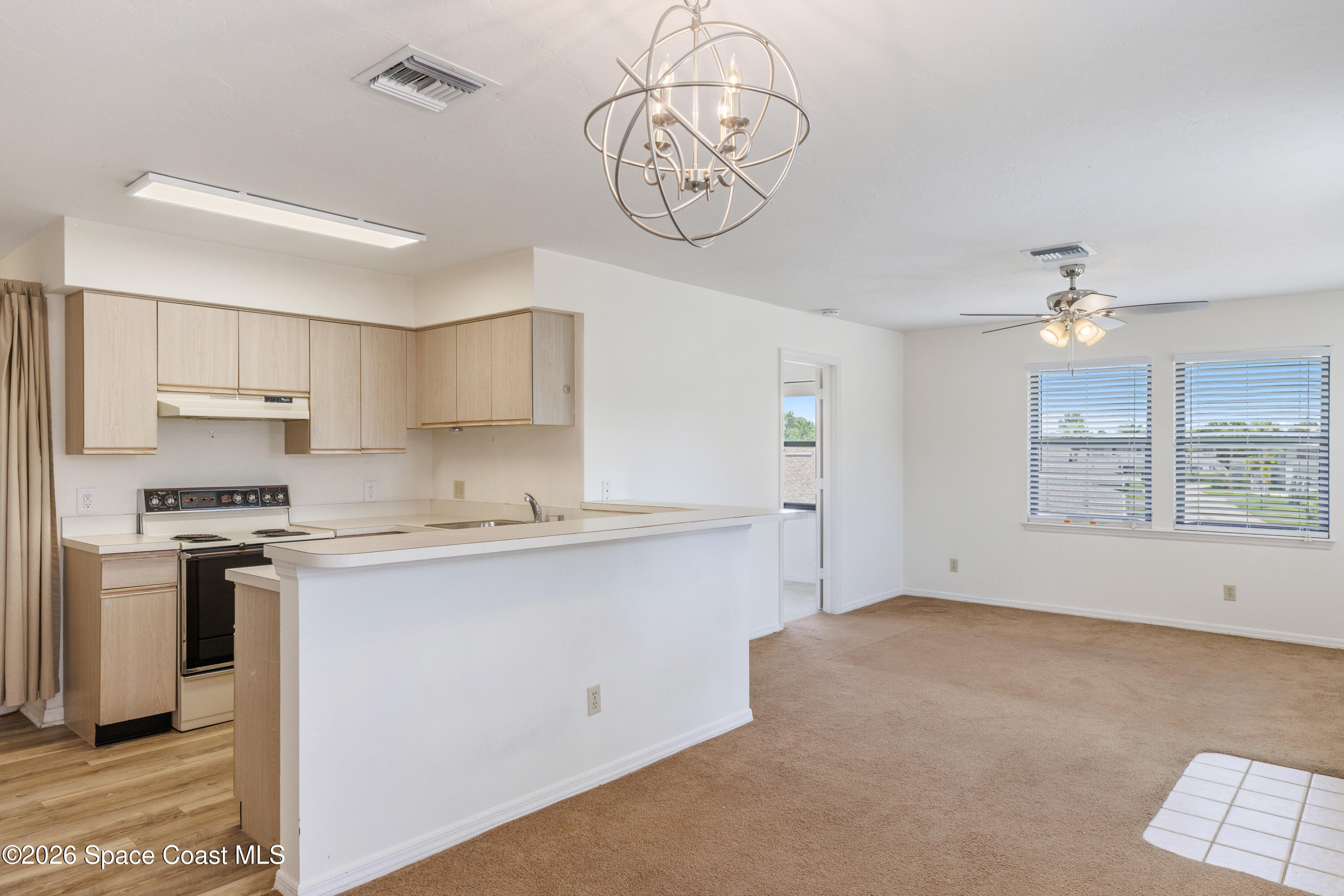654 Centre Court Southwest, Unit 201 Vero Beach, FL 32962 - Photo 1 of 20 a kitchen with stainless steel appliances and a chandelier