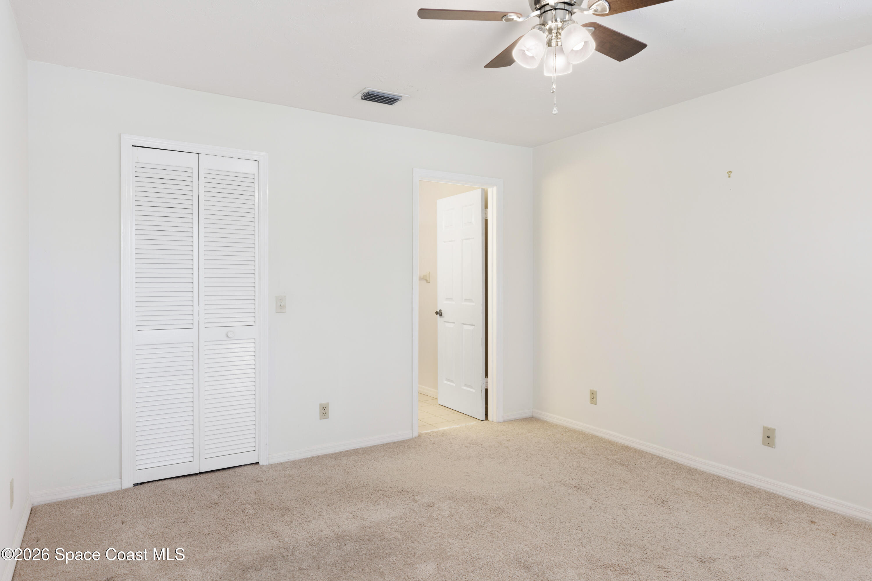 654 Centre Court Southwest, Unit 201 Vero Beach, FL 32962 - Photo 11 of 20 an empty room with a chandelier fan and windows