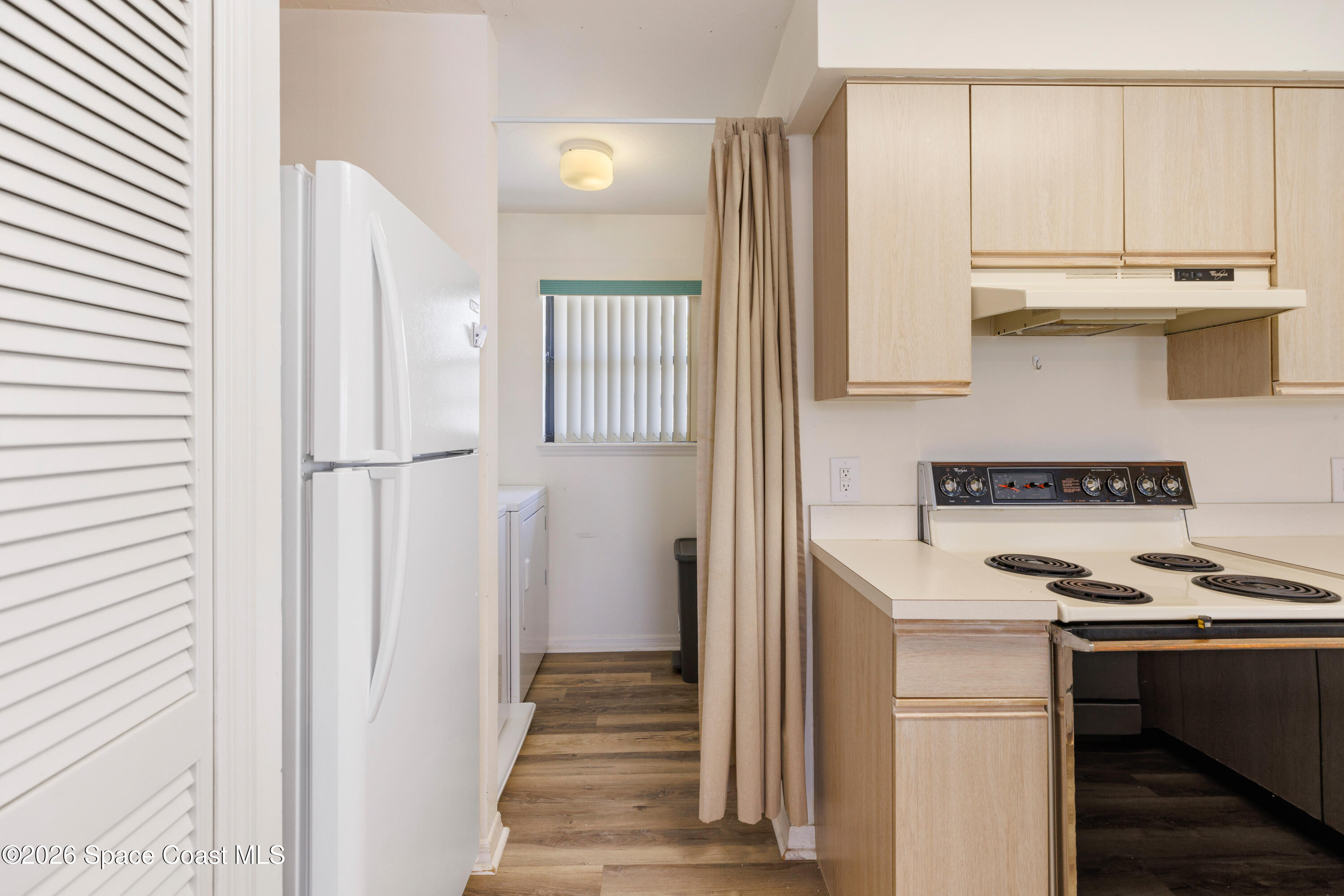 654 Centre Court Southwest, Unit 201 Vero Beach, FL 32962 - Photo 15 of 20 a kitchen with a refrigerator and a stove top oven